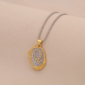 Macro view of gold letter Q pendant with cubic zirconia on elegant ball chain