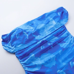 Gros plan sur l'imprimé floral bleu et la texture froncée d'une robe d'été