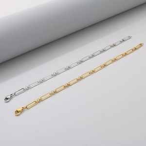 Gros plan de bracelets en chaîne trombone en acier inoxydable doré et argenté avec fermoirs
