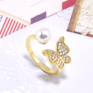 Detailed macro view of a gold-plated butterfly ring with sparkling zircon and pearl accent