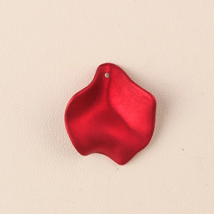 Dettaglio di un ciondolo a petalo in acrilico rosso con foro per orecchini DIY