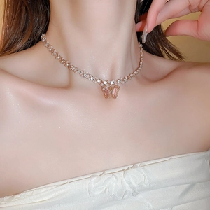 Detailed view of butterfly choker necklace with pink zircon and white pearls on a model