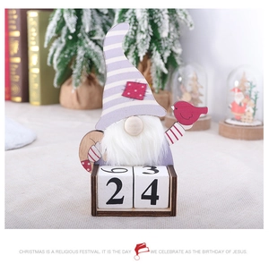 Close-up of a wooden Christmas gnome calendar with number blocks and a small red bird
