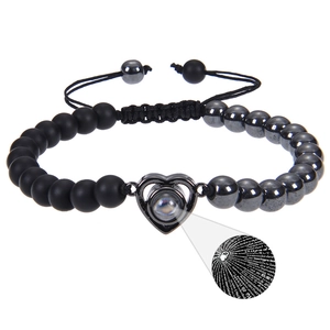 Detail of adjustable black beaded bracelet with heart-shaped 100 languages projection stone