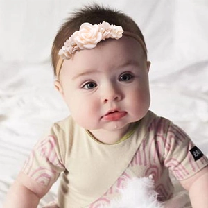 Detail of peach fabric flower headband for babies with pearls and rhinestones
