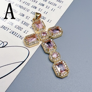 Detailed close-up of golden cross pendant with pink gemstones on a vintage paper backdrop