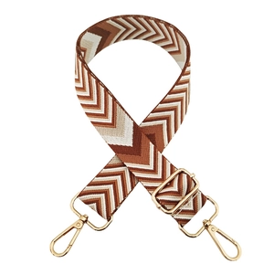 Close-up of chevron woven bag strap with adjustable golden buckle and lobster clasps
