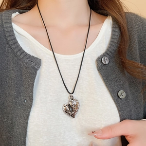 Close-up of leopard print heart pendant on minimalist black wax cord necklace