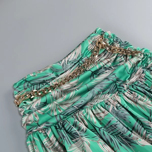 Detail of tropical print skirt with elastic waist and decorative gold metal chain