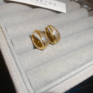 Detail shot of gold U-shaped earrings with micro-pave cubic zirconia on a velvet tray