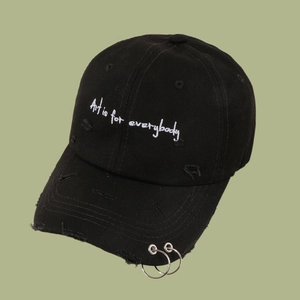 Detail of black cotton denim baseball cap with metallic rings and Art is for everybody embroidery
