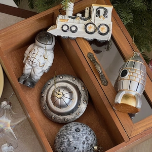 Detailed set of space-themed Christmas ornaments featuring astronauts and UFOs in a gift box