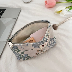 Detailed view of French floral embossed cosmetic bag with silver zipper and inner lining