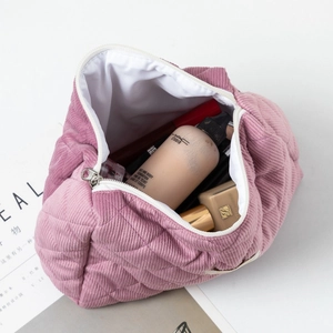 Détail de la trousse de maquillage en velours côtelé rose avec motif losange matelassé