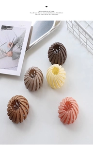 Matte finish bird nest hair clip set in five neutral colors on a white minimalist tray