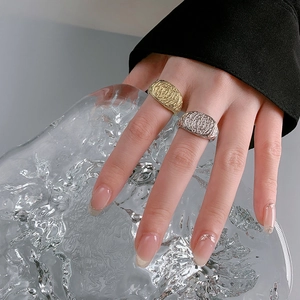Detail of silver and gold open rings with irregular lava texture on hand model