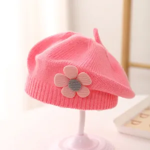 Close-up of pink knit beret featuring a 3D flower detail and soft wool texture