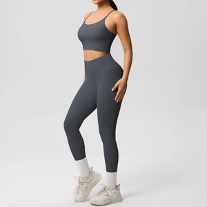 Detail of high-waist yoga leggings and strappy sports bra in charcoal grey fabric