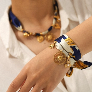 Silk scarf wrapped gold titanium necklace and bracelet set with elephant and sun charms