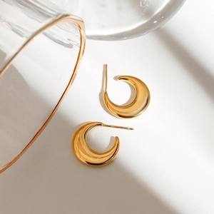 Close-up of gold-plated 18K stainless steel C-shaped earrings with a glossy finish