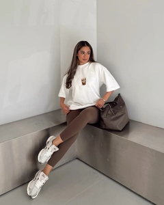 Détail d'un t-shirt blanc en coton surdimensionné avec motif café et leggings marron