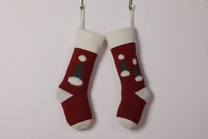 Detail of red knitted Christmas stockings with white trim and festive hat patterns