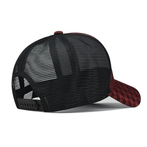 Detail of red houndstooth trucker hat featuring black mesh back and adjustable snapback