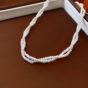 Collana di perle a doppio strato con un zircone centrale brillante su pelle scura