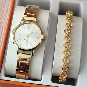 Close-up of golden women's watch and rhinestone heart bracelet in a premium orange gift box