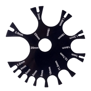 Black acrylic body piercing gauge wheel with precise measurement notches for jewelry sizing