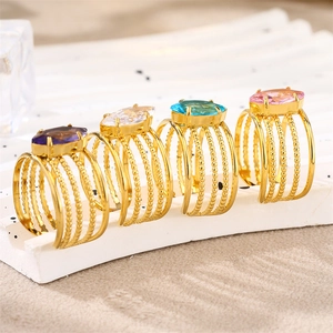 Detail of gold-plated rings with marquise-cut colorful zircons on a white display