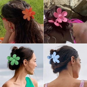 Daisy flower hair claws in matte orange, pink, green and blue shown on a model