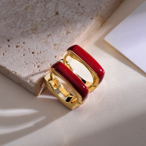 Detail of square gold hoop earrings with deep red enamel finish and hinged closure