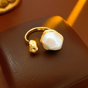 Détail d'une bague perle ovale plaquée or sur un écrin à bijoux en cuir luxueux
