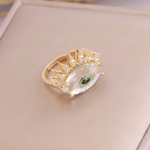 Macro detail of gold evil eye ring with green pupil and zircon pavé on velvet display