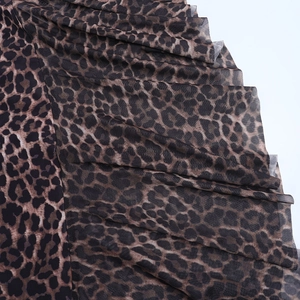 Close-up detail of leopard print sheer mesh fabric with pleated multi-layer design