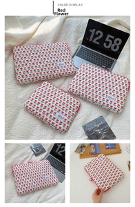 Detailed close-up of the red tulip quilted pattern and zipper on the white laptop sleeve