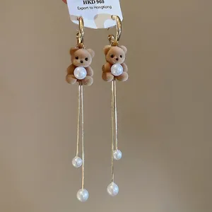 Brown flocked bear earrings with pearl accents and long gold tassels on white card