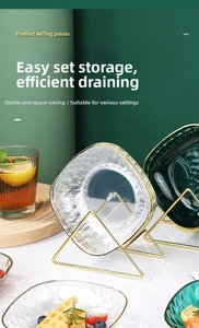Détail d'assiettes en verre avec texture diamant sur un égouttoir en métal doré luxueux