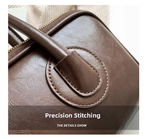 Detail view of precise stitching and premium leather texture on a brown shoulder bag