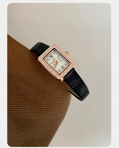Dettaglio dell'orologio rettangolare oro rosa con cristalli e cinturino in pelle nera