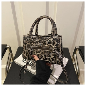 Dettaglio borsa leopardata con tasca frontale a zip e decorazione con nappe lunghe