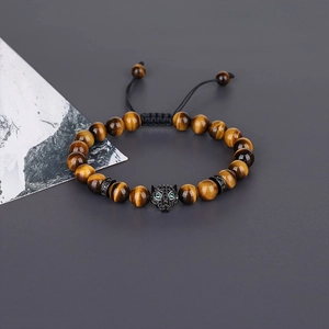 Macro detail of men's tiger eye beaded bracelet with leopard head and zircon eyes
