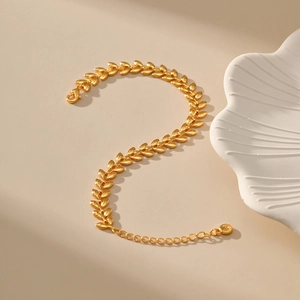Elegant 18K gold-plated wheat-ear link bracelet with lobster clasp on a warm beige surface