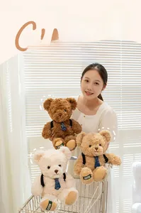 Detail of plush teddy bears in brown and white with cute blue ties and backpacks