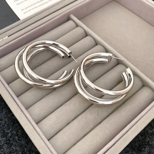 Detailed view of silver layered round hoop earrings in a grey velvet jewelry box