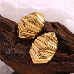 Détail des boucles d'oreilles géométriques plaquées or 18 carats sur bois texturé