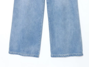 Détail de l'ourlet du pantalon en jean bleu clair avec coutures nettes et texture denim