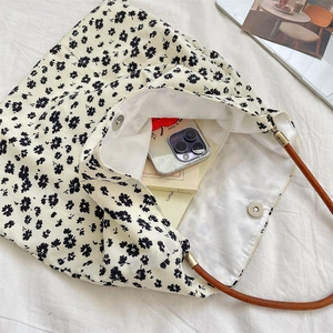 Détail intérieur du sac cabas floral en toile avec fermeture magnétique et objets du quotidien