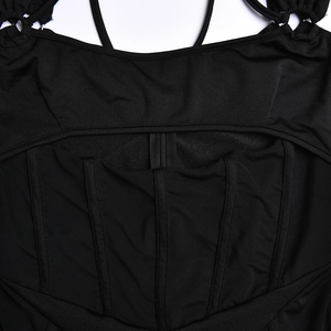 Détail du dos de la robe moulante noire avec empiècements en résille, baleines et fermeture